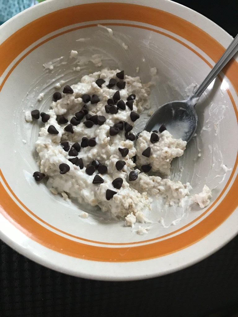 Oats mixed with vanilla yogurt and mini chocolate chips for breakfast or snack.