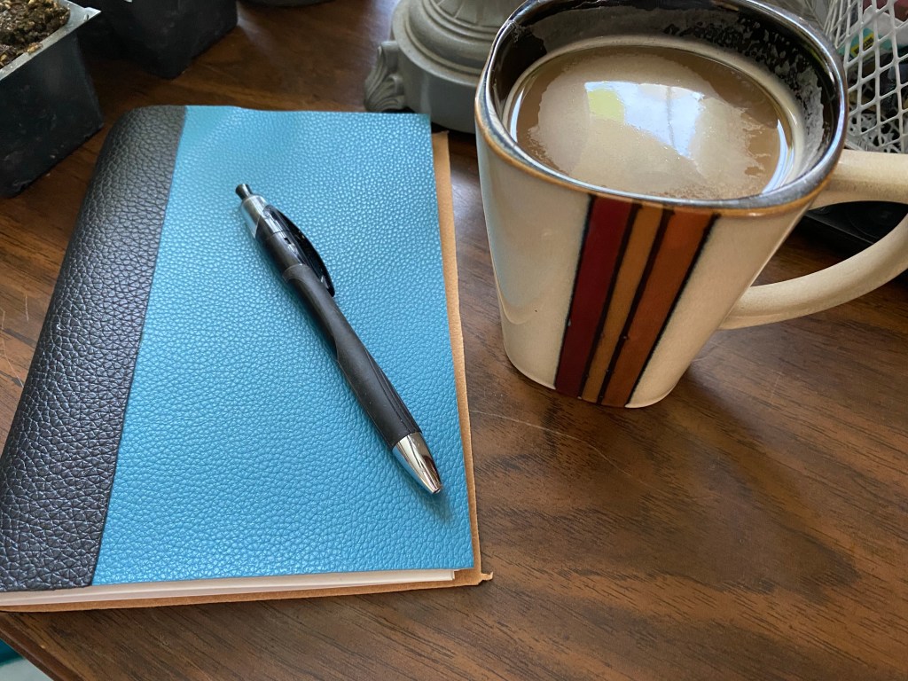 Photo of my hand made pleather journal next to my coffee mug 