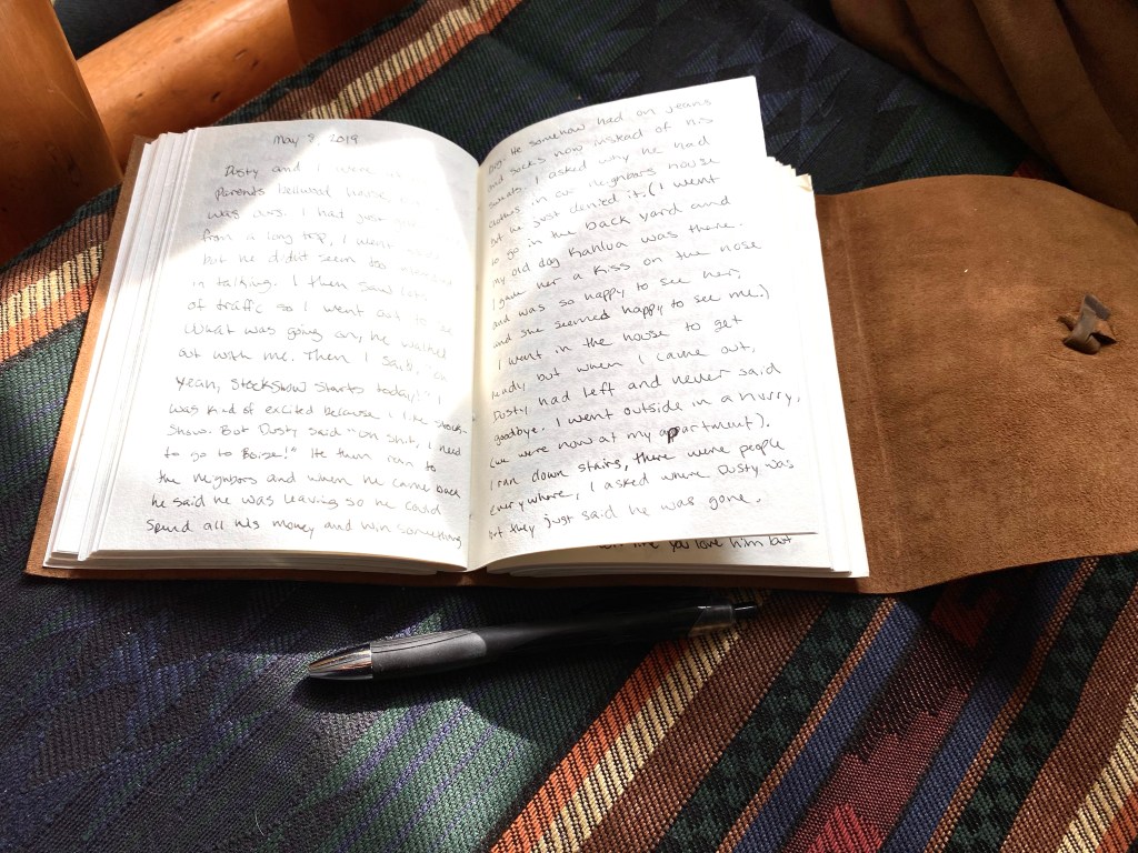 Leather bound journal opened with the sun and shadows across the words